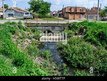 Sehr verschmutzten Fluss, der durch das Dorf fließt. Stockfoto