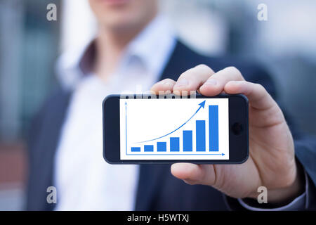 Erfolgreicher Geschäftsmann stolz Verbesserung auf Smartphone anzeigen Stockfoto