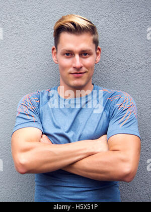 Porträt von hübschen jungen blonden Sportler lächelnd in die Kamera Stockfoto