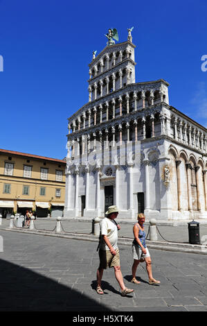 Touristen schlendern vor der beeindruckenden Kirche San Michele in Foro, Lucca, Italien Stockfoto