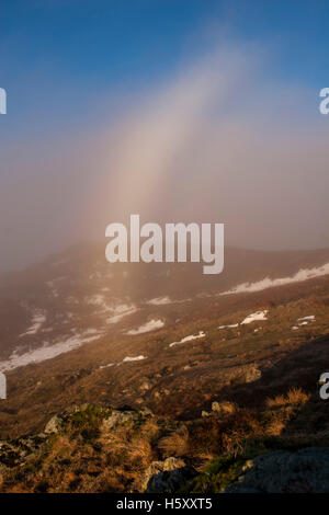 Ein Fogbow-Bögen über dem Pfad in der Nähe von Heron Hecht auf der Fairfield-Hufeisen-Wanderung im Lake District. Stockfoto