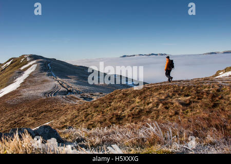 Bergsteiger geht in Richtung Heron Hecht auf das Fairfield Hufeisen über eine Temperaturinversion im Lake District, Cumbria. UK Stockfoto