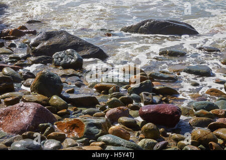 Surfen Sie an einem steinigen Strand in Wales, UK. Stockfoto