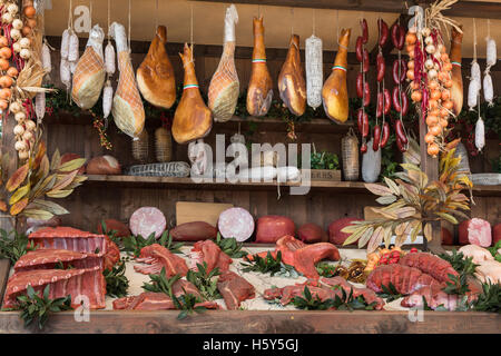 Vielzahl von rohem Fleisch und Wurstwaren in Metzgerei auf Holzbrett Stockfoto