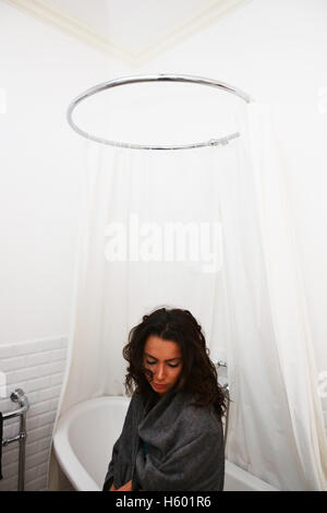 junge Frau sitzt am Rand des Bades in Luxus-Badezimmer Leben betrachten Stockfoto