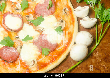 Pizza mit Salami und Mozzarella-Käse mit Pilzen und Petersilie Stockfoto