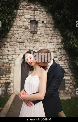 Herrlich frisch vermählte posiert in der Nähe schöne Wand Pflanzen Sträucher Bäume in ihrem Hochzeitstag Stockfoto