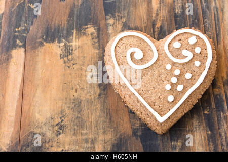 Lebkuchenherz Cookie auf einem rustikalen hölzernen Hintergrund. Stockfoto