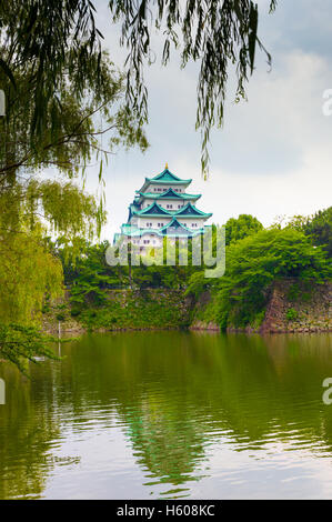 Hängende Blätter Rahmen die historischen Burg Nagoya Hochburg oberhalb einer wässrigen Graben und stark befestigte Wallanlage in Japan. Vertikal Stockfoto