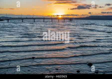 Die Sonne geht hinter dem Fishing Pier in Des Moines, Washington. Stockfoto