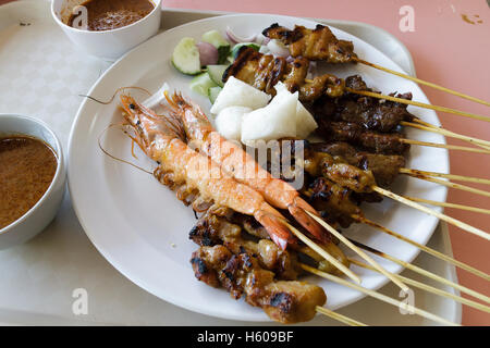 Teller mit gemischten Satay bestehend aus Huhn, Rindfleisch, Schweinefleisch, Hammelfleisch und Garnelen am Spieß mit Erdnuss Dip-sauce, Singapur Stockfoto