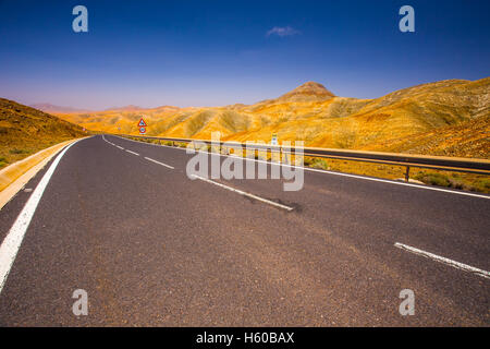Die Straße führt durch den vulkanischen Bergen der Insel Fuerteventura, Kanarische Inseln, Spanien, Europa. Stockfoto
