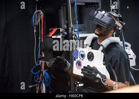 Französischer Basketballspieler Tony Parker von den San Antonio Spurs Proben virtual-Reality-Hardware, die simuliert eine EVA Weltraumspaziergang im Johnson Space Center Raum Fahrzeug Mockup Anlage virtuelle Realität Labor während einer Führung unter Leitung von französischer Astronaut Thomas Pesquet von der European Space Agency 2. April 2015 in Houston, Texas. Stockfoto