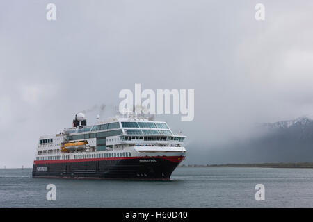 Hurtigruten Kreuzfahrtschiff Midnight Sun nähert sich dem Dock bei Risoyhamn, Andoya Bridge, Norwegen. Stockfoto