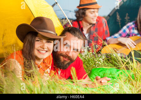 Junges Paar liegen auf dem Rasen neben ihrem Zelt Stockfoto