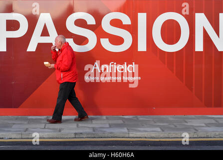 Ein Mann isst Erfrischungen während er Vergangenheit geht ein 'Passion' Zeichen im Stadium vor der Premier League an der Anfield Road, Liverpool übereinstimmen. Stockfoto