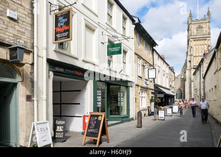 Ein Blick in Richtung Kirche St. Johannes der Täufer von Black Jack Straße in Cirencester, Gloucestershire, UK Stockfoto