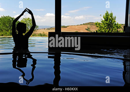 Die Silhouette einer Frau in den thermal-Innenpool von Fonteverde Natural Spa Resort in San Casciano dei Bagni, in der Nähe von Siena. Stockfoto