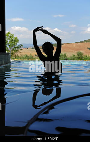 Die Silhouette einer Frau in den thermal-Innenpool von Fonteverde Natural Spa Resort in San Casciano dei Bagni, in der Nähe von Siena. Stockfoto