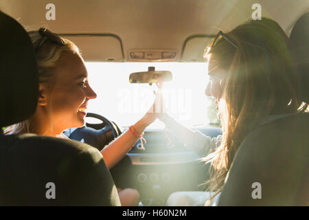 glückliche Mädchen oder Frauen im Auto fahren Stockfoto