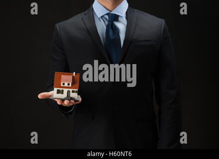 Nahaufnahme von Geschäftsmann hält Hausmodell Stockfoto