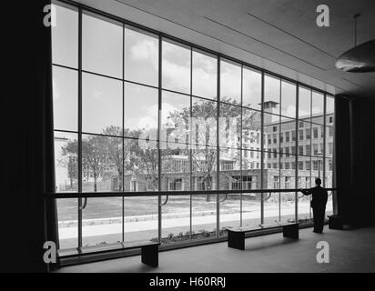 Mann auf der Suche durch große Fenster in Akustik Foyer, Bell Telephone Laboratories, Murray Hill, New Jersey, USA, Gottscho Schleisner Sammlung, Mai 1942 Stockfoto