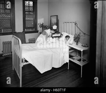 Krankenschwester bringt neugeborenes Kind zur Mutter im Krankenhaus Zimmer, Garfield Hospital, Washington, DC, USA, National Photo Company, 1921 Stockfoto