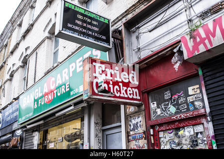 Alten gebraten Huhn Ladenschild neben einem Teppich und Möbel-Shop in East London Stockfoto