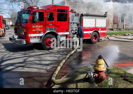 Feuerwehrauto Pumper angeschlossen um Feuer Hydrant bei Hausbrand, Detroit, Michigan/USA Stockfoto