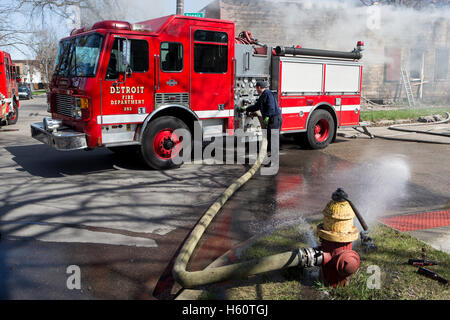 Feuerwehrauto Pumper angeschlossen um Feuer Hydrant, Ausarbeitung und Pumpen von Wasser, bei Hausbrand, Detroit, Michigan/USA Stockfoto