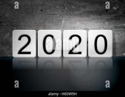 Das Wort "2020" in weißen Fliesen vor dem dunklen Vintage Grunge Hintergrund geschrieben. Stockfoto