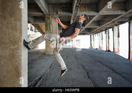 Männer T-shirt von Parkour im urbanen Raum. Er läuft an der Wand. Sport in der Stadt. Bewegung ist Leben. Stockfoto
