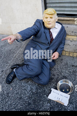 Mann in einem Donald Trump Maske und Anzug angeblich Geld zu sammeln, eine mexikanische Mauer an der Grenze zu errichten. Im Zentrum von New York City Stockfoto