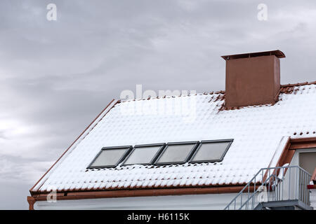 Oberlicht und roten Schornstein auf Schnee bedeckt Dach Stockfoto