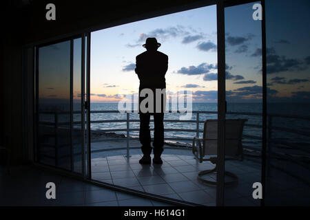 Hintere Ansicht Silhouette des Mannes auf Balkon Blick auf das Meer Stockfoto