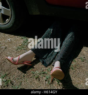 Weibliche Schaufensterpuppe, die Verlegung unter Auto Stockfoto