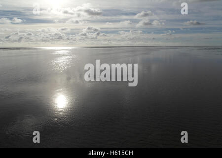 Weiße Sonne reflektiert weite Meer-Wasser-Kanal überqueren weite Sandstrand unterhalb Cirrus, Cumulus Wolken Himmel, Fairhaven, Lytham, UK Stockfoto