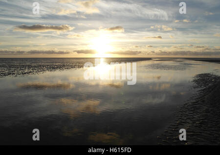 Weiße Sonneneinstellung unter kleinen Stratocumulus Wolken Reflectiong in einem Meer-Wasser-Kanal auf einem Ebbe Strand, Fairhaven, Lytham, UK Stockfoto