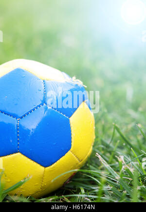 alte Fußball auf dem Feld und kleine Kies mit Sonnenschein Stockfoto