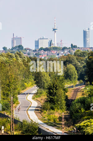 Radweg Rheinische Bahn zwischen Essen und Mülheim, ehemalige Eisenbahnstrecke, erweitert um einen Zyklus und Gehweg, Skyline von Essen Stockfoto