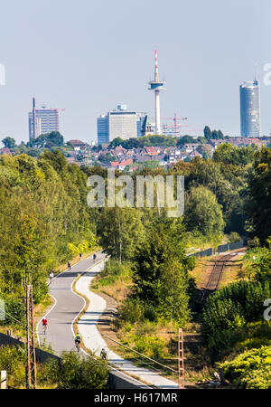 Radweg Rheinische Bahn zwischen Essen und Mülheim, ehemalige Eisenbahnstrecke, erweitert um einen Zyklus und Gehweg, Skyline von Essen Stockfoto