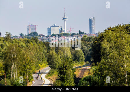 Radweg Rheinische Bahn zwischen Essen und Mülheim, ehemalige Eisenbahnstrecke, erweitert um einen Zyklus und Gehweg, Skyline von Essen Stockfoto