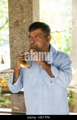 Mann bläst einen traditionellen Horn am Puja, Lankatilake Tempel aus dem 14. Jahrhundert, Kandy, Sri Lanka Stockfoto