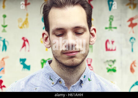 Porträt von verärgert junger Mann steht vor einem bunten funky Hintergrund Stockfoto