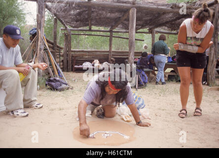 Navajo Führer schaffen eine Sandmalerei vor Gruppe von Wanderern, Canyon de Chelly National Monument, Arizona Stockfoto