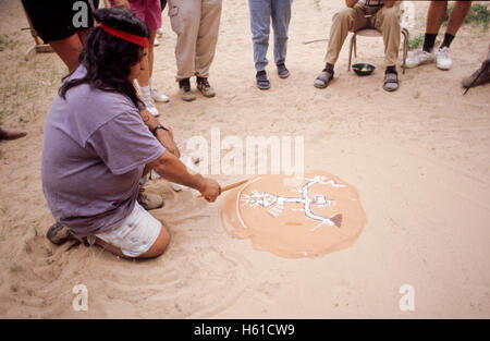 Navajo Führer schaffen eine Sandmalerei vor Gruppe von Wanderern, Canyon de Chelly National Monument, Arizona Stockfoto