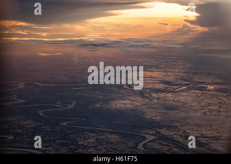 Sonnenaufgang über der Erde. Sonnenlicht bricht durch die Wolken und beleuchtet die Erde durch die ersten Strahlen der Sonne Stockfoto