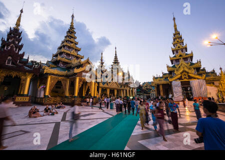 Menschen in der Shwedagon-Pagode in Yangon in der Abenddämmerung Stockfoto