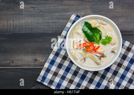 Kokosmilch Suppe mit Huhn oder Thai Hühnchen Kokos Suppe (Tom Kha Gai) Holztisch Draufsicht, thailändische Spezialitäten Stockfoto