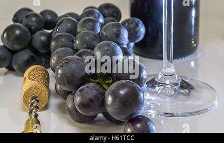 Trauben von Glas, Korkenzieher und Flasche Rotwein Stockfoto